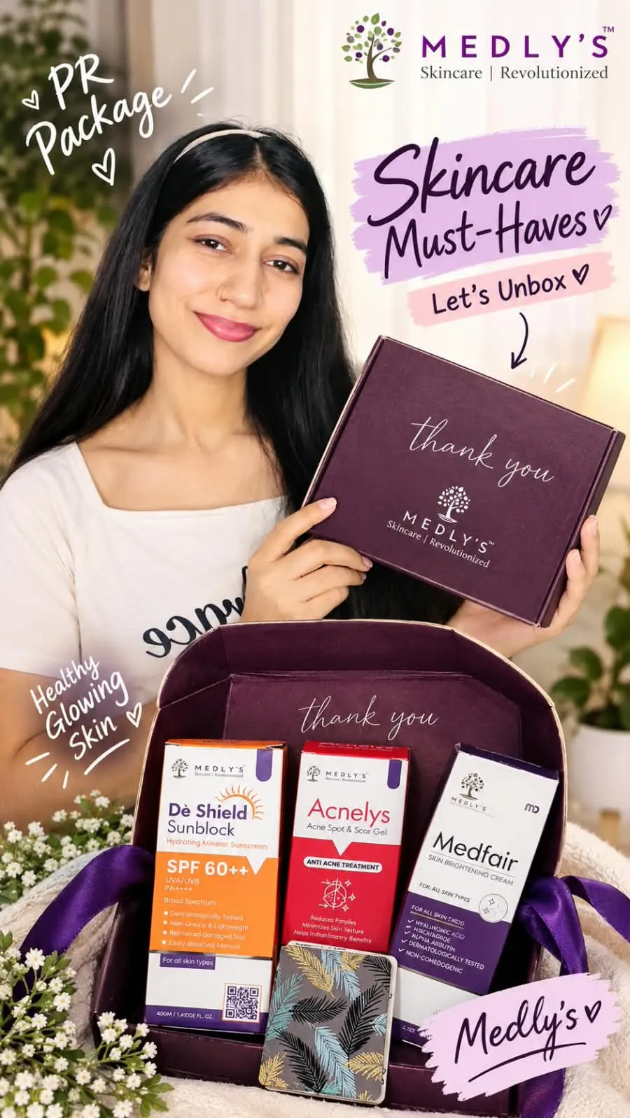 A beauty creator holds a MEDLYS PR package featuring De Shield SPF 60++ Sunblock, Acnelys Acne Spot & Scar Gel, and MedFair Skin Brightening Cream in a premium burgundy gift box decorated with purple ribbons and flowers.