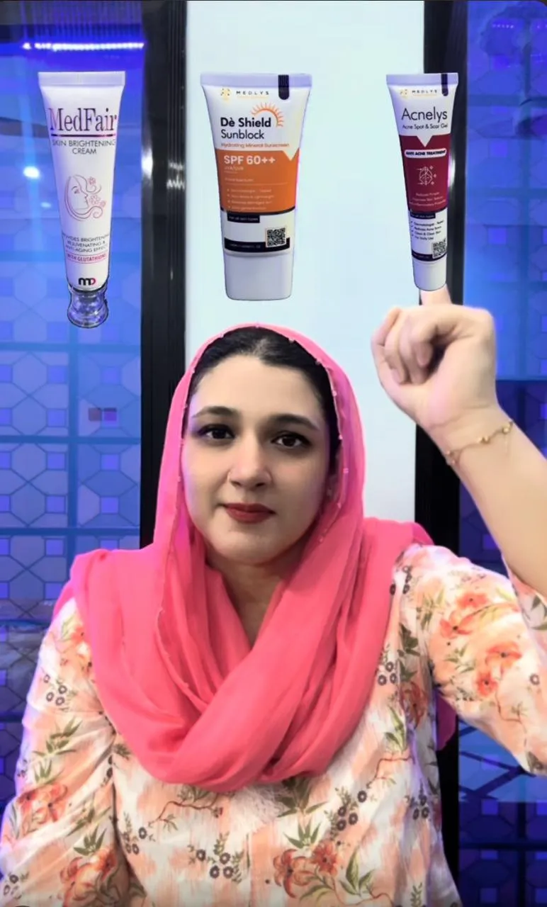 A woman wearing a pink headscarf presents MEDLYS skincare products, including MedFair Skin Brightening Cream, De Shield SPF 60++ Sunblock, and Acnelys Acne Spot & Scar Gel, against a blue illuminated background.